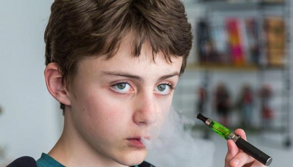 مراهق يدخن السجائر الإلكترونية  