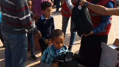 الهلال الأحمر يواصل توزيع شنط المدارس ببئر العبد.. صور