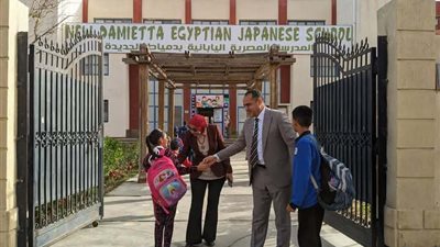 مدير مدرسة يستقبل التلاميذ أمام البوابة لتهنئتهم بالعيد